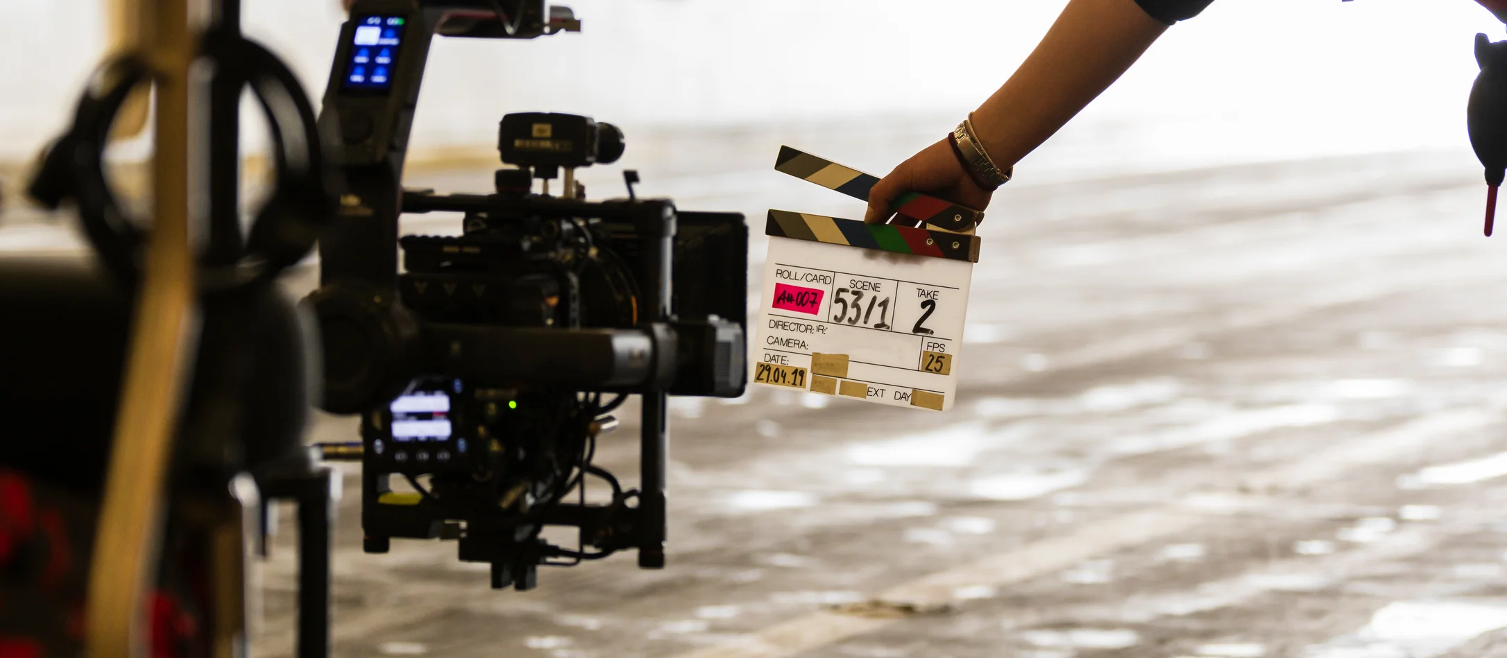 Filmklappe wird vor eine Filmkamera gehalten
