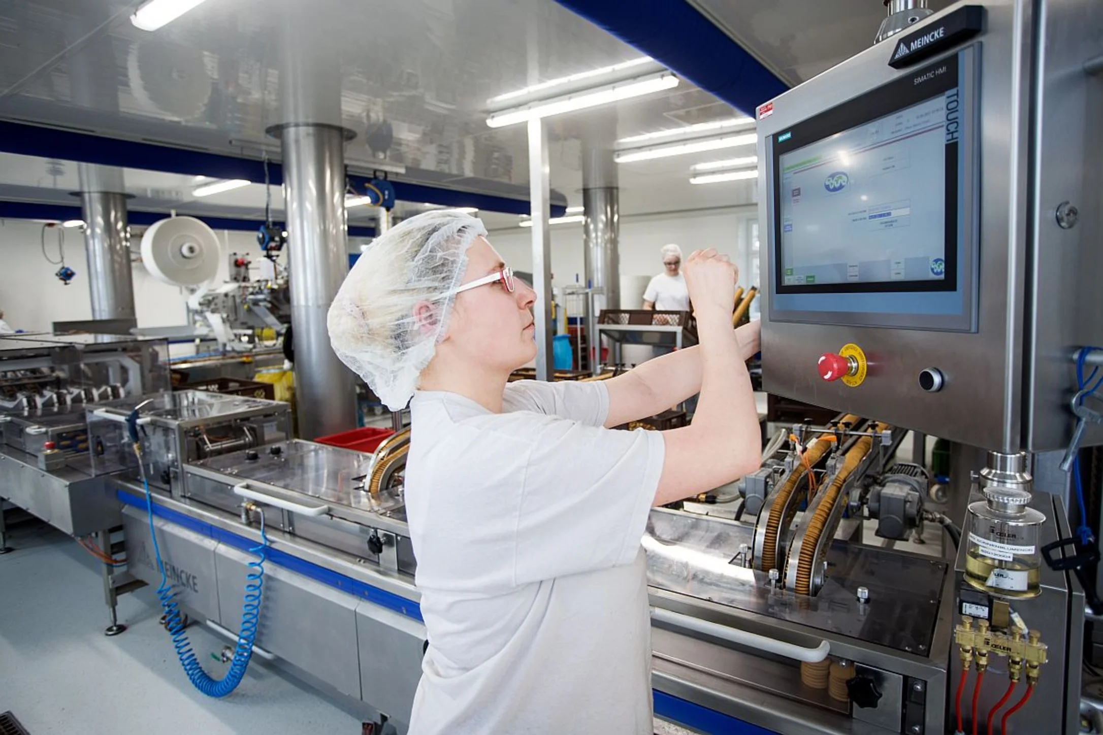 Eine Frau arbeitet an einer modernen Produktionsmaschine
